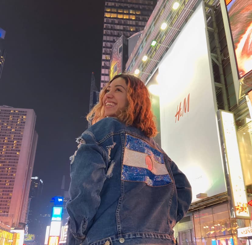 Adriana standing and looking back with Times Square in the background